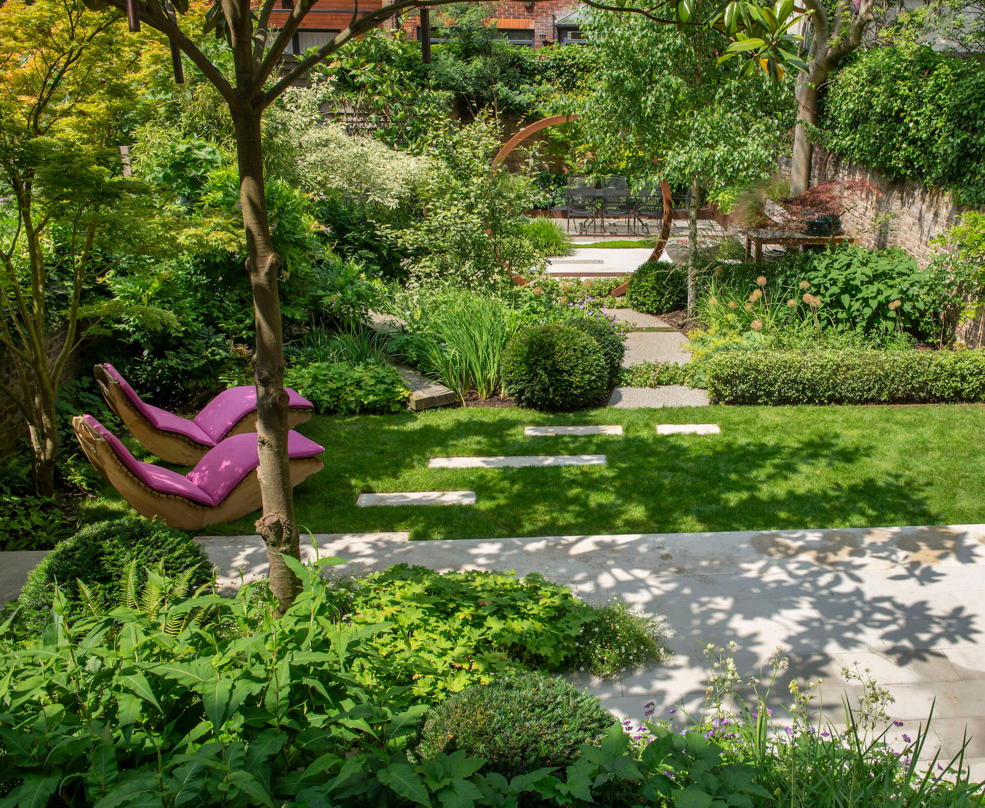 The view from the first floor balcony shows the structure of the garden. The pruned existing Magnolia creates lovely shadows on the poured concrete and sandstone patio.